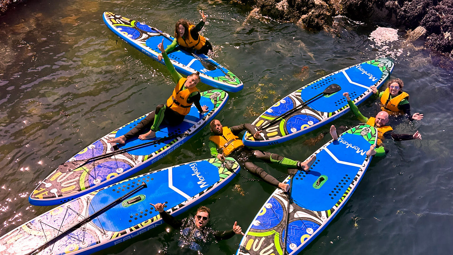 Paddleboarders relaxing with their boards in a rockpool